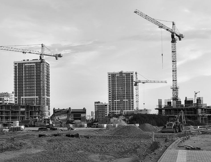 Construction site with tall tower cranes and heavy equipment vehicles